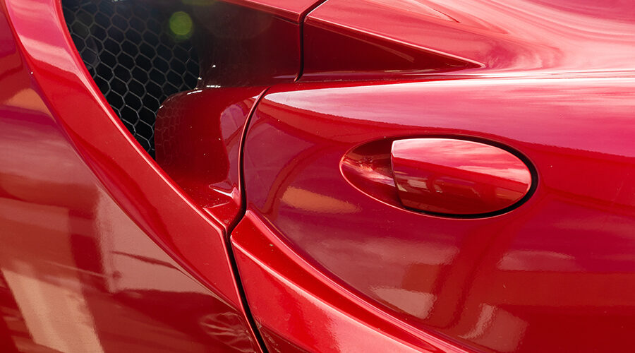 A closeup shot of the door handle of a modern red car